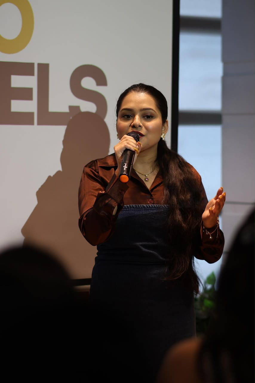 Disha speaking into a microphone during a career session on stage